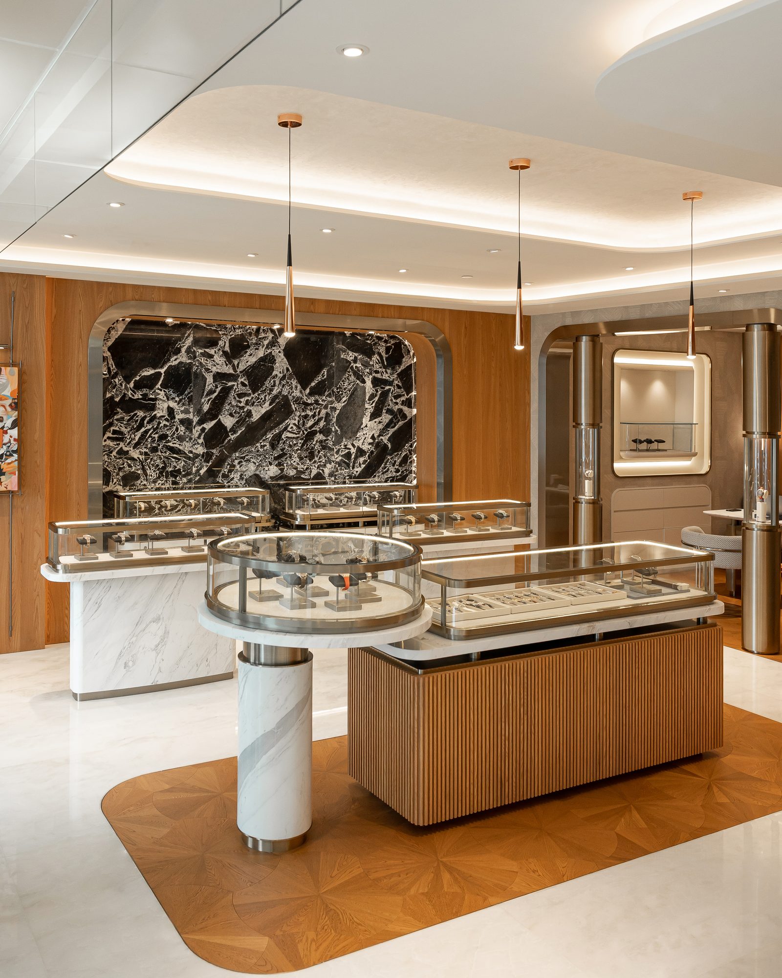 Luxury watches in stock at the SHK Watches Hong Kong showroom, displayed in lit glass cases against a black marble wall
